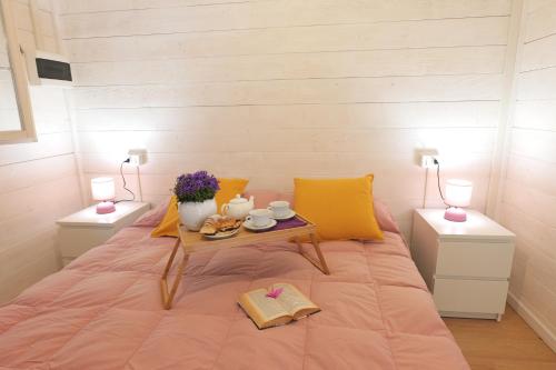 a bedroom with a bed with a table on it at CAMPING CALATELLA parco di vacanza in Marina di Massa