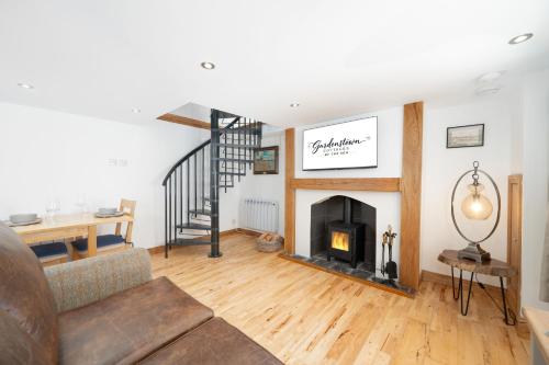 a living room with a fireplace and a staircase at Nautical Nook, 16 Seatown, Gardenstown in Gardenstown