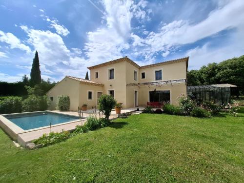 une maison avec une piscine dans une cour dans l'établissement La gloriette, à Saumane-de-Vaucluse
