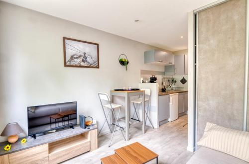 Il comprend un salon et une cuisine avec une table et une télévision. dans l'établissement Villeurbanne - Studio aux portes de Lyon, à Villeurbanne