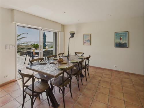 une salle à manger avec une longue table et des chaises dans l'établissement Les pieds dans l'eau pour 6 à Larvor, à Loctudy
