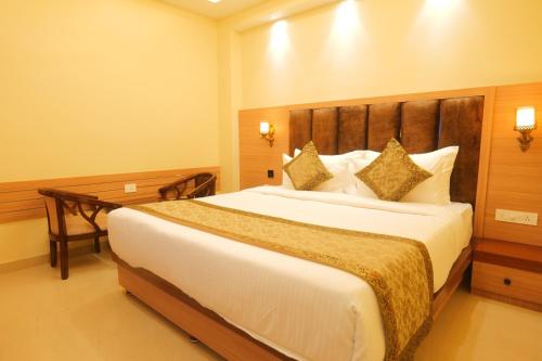 a bedroom with a large bed and a desk at Hotel Mantavya in Kakarmatha