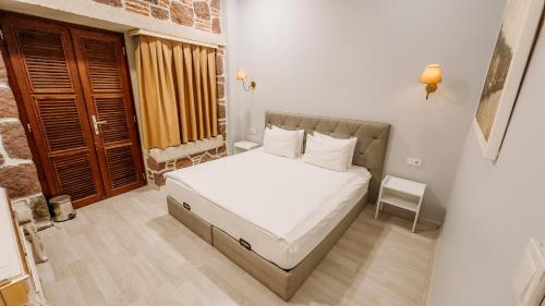 a bedroom with a bed with white sheets and a window at L'Agora Old Town Hotel & Bazaar in Izmir
