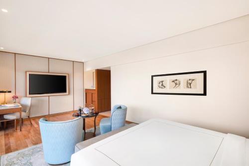 a room with a table and chairs and a television at Taj Surajkund Resort & Spa, Delhi NCR in Faridabad