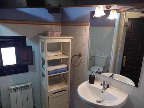 a bathroom with a sink and a toilet and a mirror at Casas Recuero in Chinchón