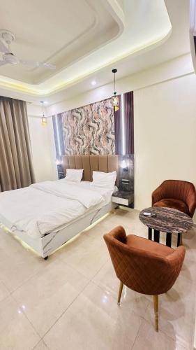 a bedroom with a bed and a table and a chair at Snooze and Stay Omaxe Hazratganj in Lucknow