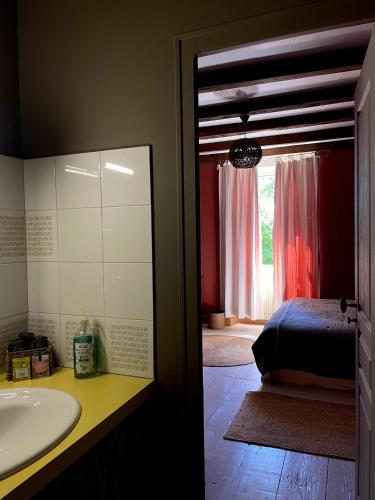 La salle de bains est pourvue d'un lavabo, d'un lit et d'une fenêtre. dans l'établissement Au domaine d'Alice, à Saint-Laurent-sur-Gorre