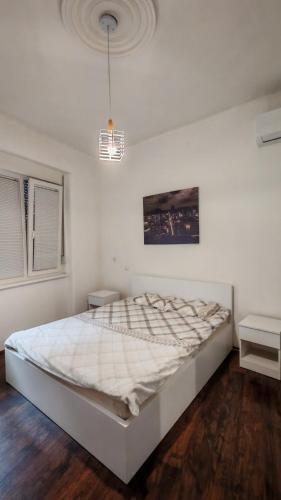a white bedroom with a large bed in a room at ZELENI VENAC Studio & Apartment in Belgrade
