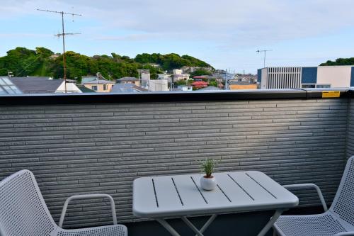 a white table and chairs on a balcony at 鎌倉 江ノ島 新築貸切一戸建て全館浄水システム完備 海近く 江ノ島が見える 露天テラス 無料駐車2台付 in Kamakura