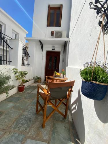 a patio with a chair and a table and potted plants at Adele house in Skopelos Town
