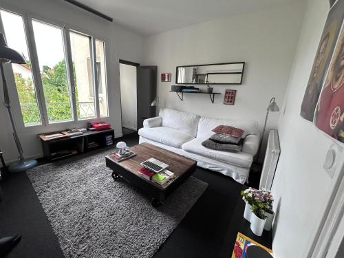 un salon avec un canapé blanc et une table basse dans l'établissement Super appart à Clamart 3 pièces - 7 min gare, à Clamart