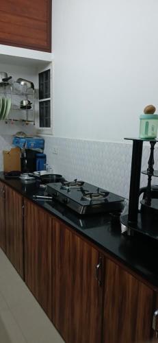 a kitchen with a counter with a stove top at annies inn homestay in Cochin