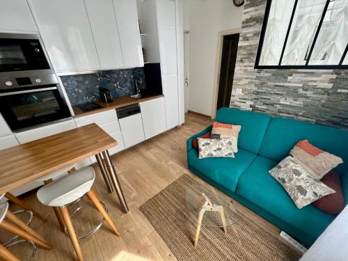 un salon avec un canapé bleu et une table dans l'établissement T2 centre ville de Nice face de la gare routière Nice ville, à Nice