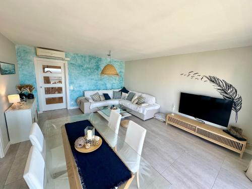 a living room with a couch and a tv at Ático céntrico con amplias vistas mar y playa in Roses