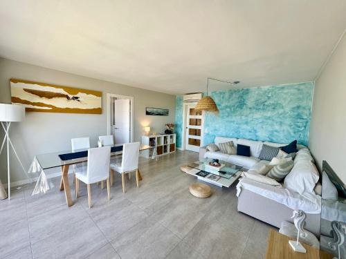a living room with a couch and a table at Ático céntrico con amplias vistas mar y playa in Roses