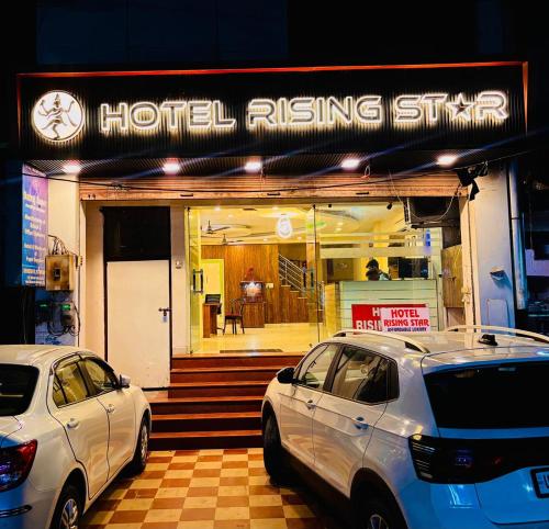 two cars parked in front of a hotel rising shop at Hotel Rising Star in Ghaziabad