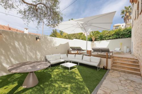 une terrasse avec un canapé, une table et un parasol dans l'établissement Immogroom - Luxury Villa with Swimming Pool in City Center, à Cannes