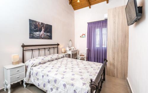 a bedroom with a bed and a tv on a wall at Villa Callisto in Yírion