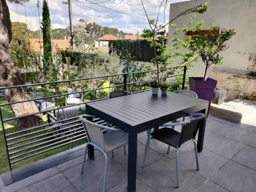 a black table and chairs on a balcony at Maison 5 personnes Piscine 10min Stade Vélodrome in Marseille