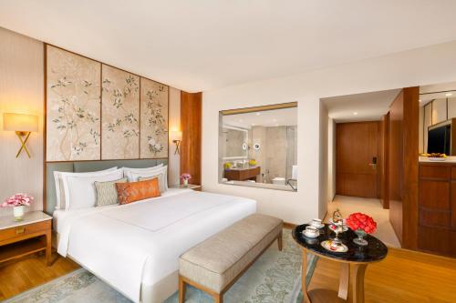 a bedroom with a large white bed and a table at Taj Surajkund Resort & Spa, Delhi NCR in Faridabad