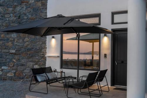 a table and chairs under an umbrella on a patio at Amenti Horizon View in Agkidia