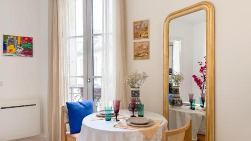 une salle à manger avec une table et un miroir dans l'établissement Escapade parisienne stylée, à Paris