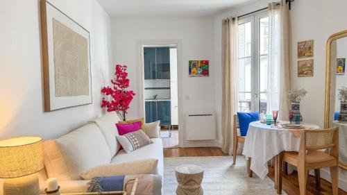 un salon avec un canapé blanc et une table dans l'établissement Escapade parisienne stylée, à Paris