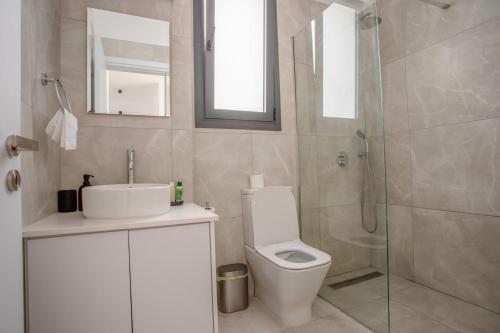 a bathroom with a shower and a toilet and a sink at Sea view Penthouse Universal Residences in Nea Paphos