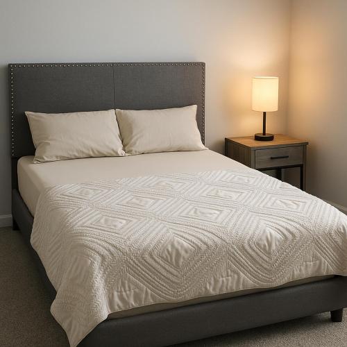 a bedroom with a bed and a nightstand with a lamp at Quiet Haven in Richmond