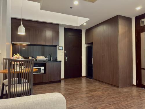 a kitchen with wooden cabinets and a table and a kitchen with a counter at Civic Horizon Hotel & Residence in Bangkok