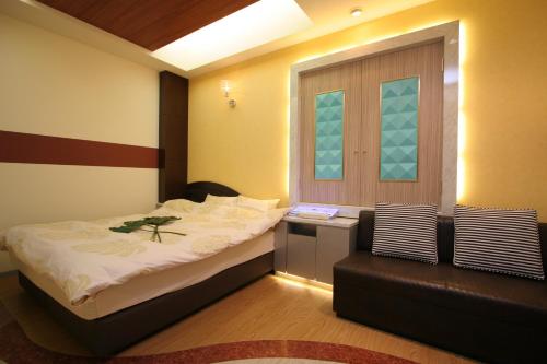 a bedroom with a bed and a chair and a window at Hotel NEX check in 13時から in Tochigi