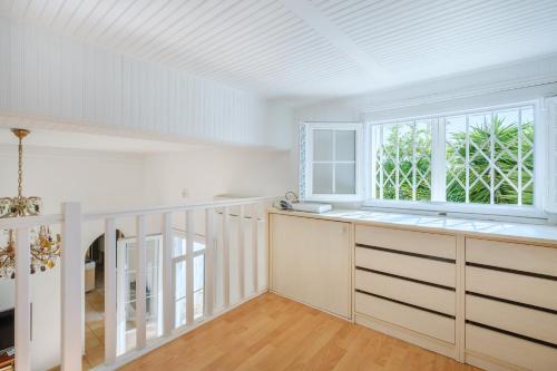 une cuisine avec des armoires blanches et une fenêtre dans l'établissement Maison Centre Cannes Avec Terrasse, à Cannes