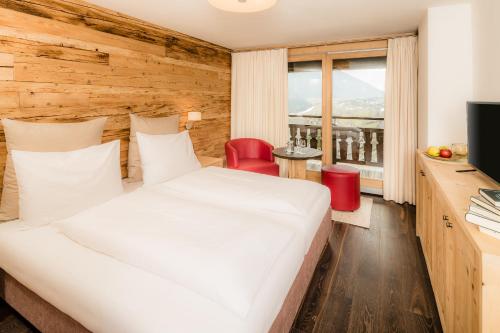 a hotel room with a bed and a television at Gasthof Eggwirt in Ultimo