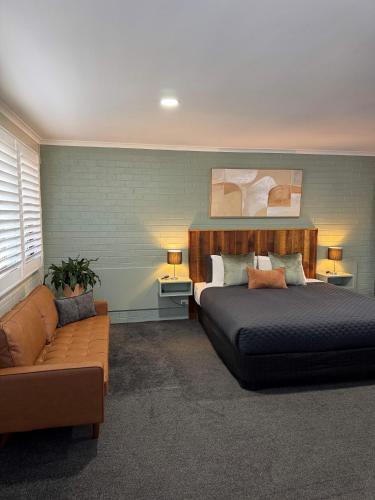 a bedroom with a bed and a couch at Central Deborah Motel in Bendigo