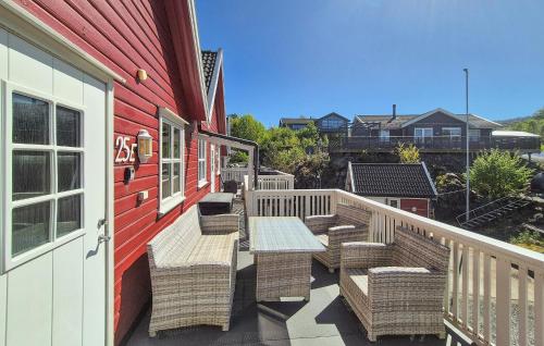 a deck with wicker chairs and a table on a house at Nice Apartment In Auklandshamn in Vestvik