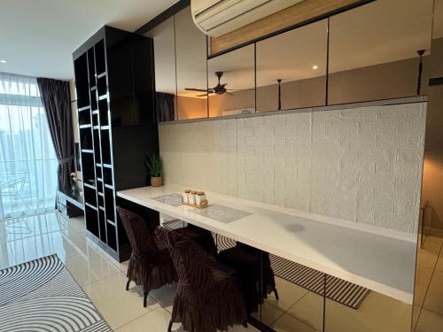 a kitchen with a counter and some brown chairs at JB City Shopping Mall Apartment in Johor Bahru