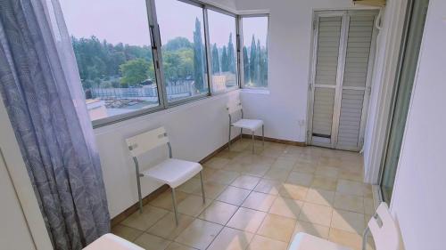Habitación con 2 sillas y ventana grande. en STAY Virtuoso Apartment, en Nicosia