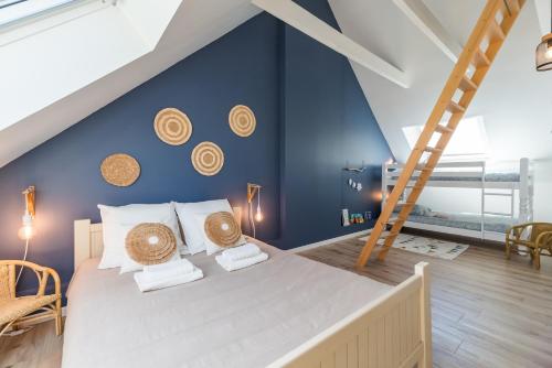 une chambre avec un grand lit avec un mur bleu dans l'établissement Un Air de Famille - proche de la plage, à Pleubian