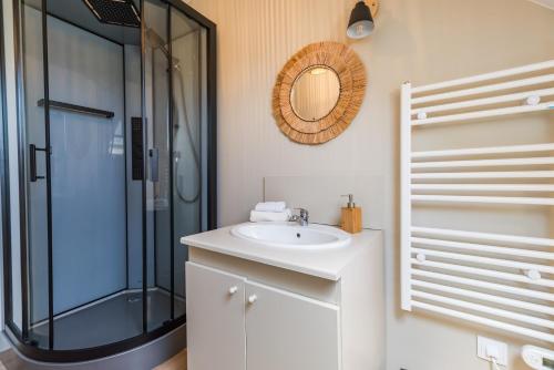 une salle de bain avec un lavabo et une douche en verre dans l'établissement Un Air de Famille - proche de la plage, à Pleubian