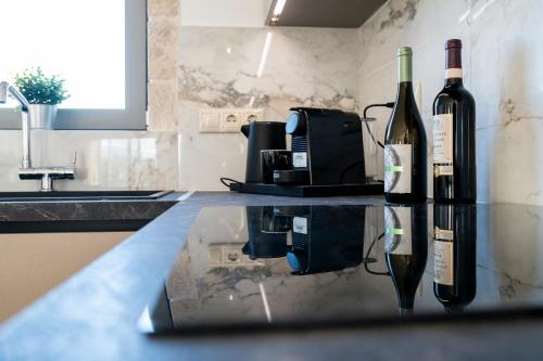 two bottles of wine sitting on a counter in a kitchen at Villa Sofita Komos View in Pitsidia