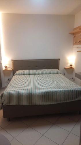 a bed in a bedroom with two lamps on two tables at Il Mughetto in Aosta