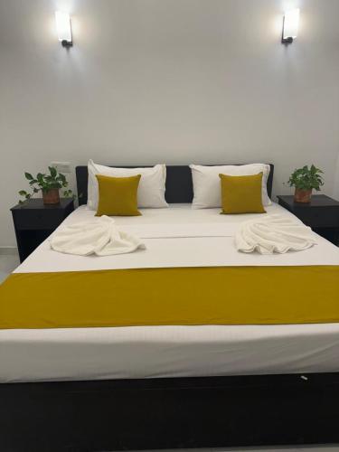 カトゥナーヤカにあるSky wing transit hotelの大型ベッド(黄色と白の枕付)