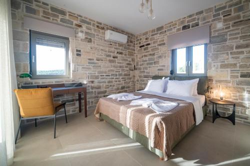 a bedroom with a bed and a desk in a room at Villa Sofita Komos View in Pitsidia