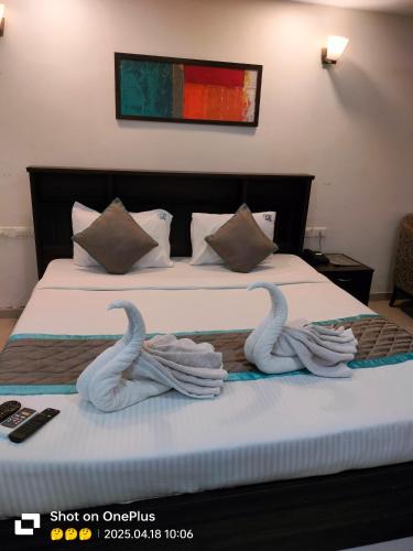 two swans made out of towels sitting on a bed at The Townhall (Unit of Prohotel) in Chennai