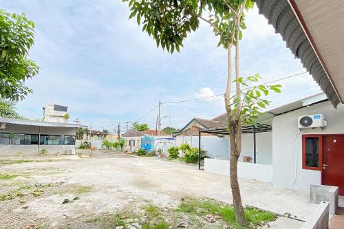 a street view of a building with a tree at RedDoorz at Graha Aisyah Menteng Medan in Polonia Airport