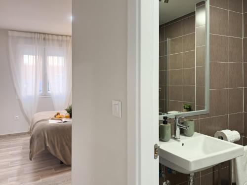 a bathroom with a sink and a bed and a mirror at ChillaHomes 002 in Candeleda