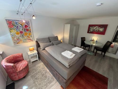una camera da letto con un letto, una sedia e un tavolo di Doppelzimmer in Stuttgart-Birkach - Nähe Musicals im SI-Zentrum, Messe, Flughafen, Uni Hohenheim a Stoccarda