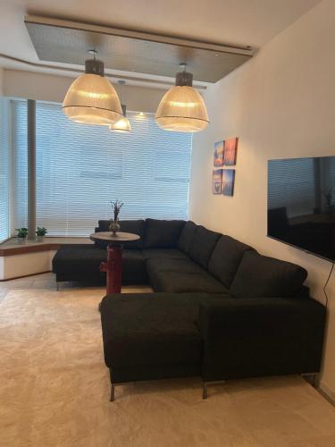 a living room with a black couch and a table at Studio Apartment Altstadt in Dorsten