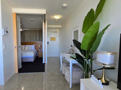 a room with a bedroom with a bed and a plant at Ocean Retreat in Yeppoon