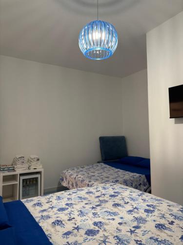 Una habitación con dos camas y una lámpara azul. en La Finestra sul Mare, en Fiumefreddo Bruzio